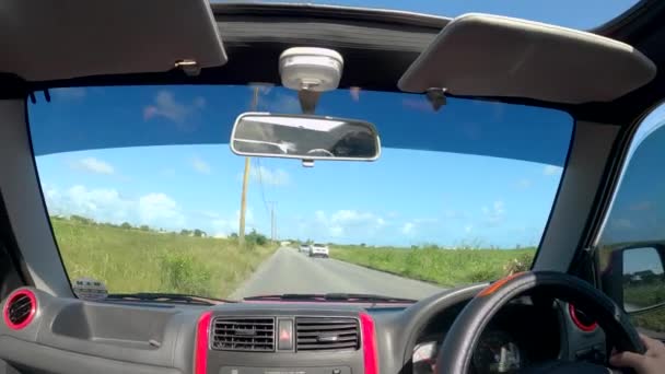 POV: Turista dirigindo seu jipe em viagem de carro em Barbados se aproxima de uma aldeia . — Vídeo de Stock