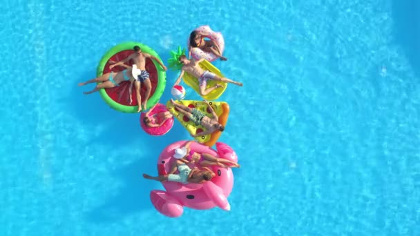 Группа друзей тусуется у бассейна и отдыхает на забавных поплавках. — стоковое видео