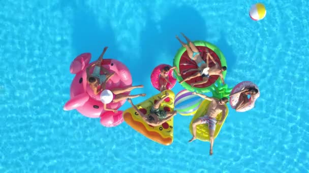 AERIAL: Веселые молодые туристы проводят жаркий летний день на прохладной вечеринке у бассейна. — стоковое видео