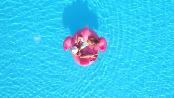 DRONE mężczyzna i jego dziewczyna na wakacjach chill na różowym flamingo floatie — Wideo stockowe