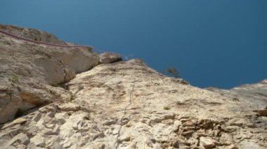 Mavi ve kırmızı halat, yüksek bir uçurumun tepesinden aşağı düşer..