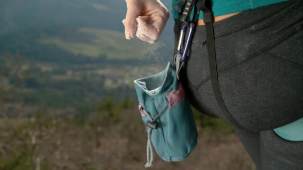 CLOSE UP: Female rock climber reaches into chalk pouch to chalk up her hand. — Stock Video