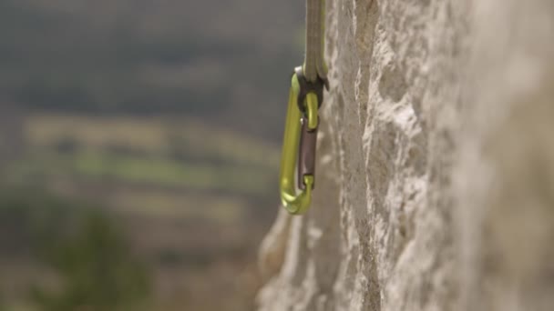 CLOSE UP: felismerhetetlen női sziklamászó kapcsok belay kötél egy karabiner. — Stock videók