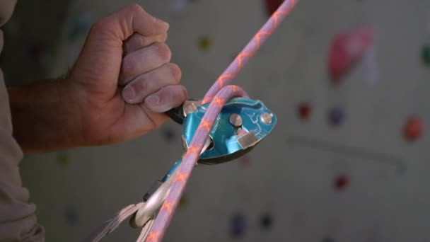 CLOSE UP: Unerkennbarer Stand hilft einem Bergsteiger beim Abstieg nach dem Klettern einer Wand — Stockvideo