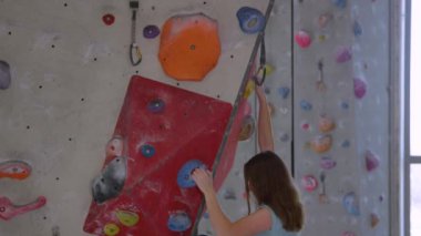 Yaklaş UP Girl, mavi bir cep tutacağı tutarken halatı bir karabinaya bağlıyor