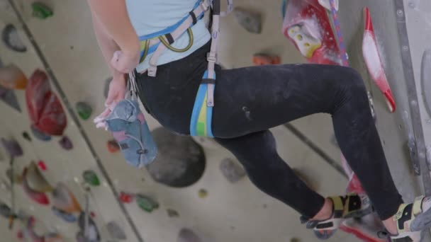 CLOSE UP: Unerkennbare Bergsteigerin greift in ihre Tasche und kreidet sich die Hände. — Stockvideo