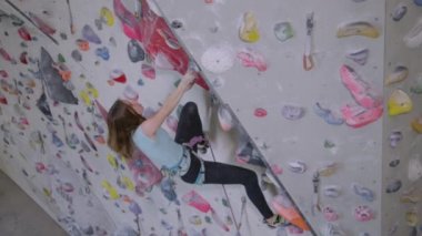 Genç kız ipini bir karabinaya bağlar ve kurşunla tırmanır.