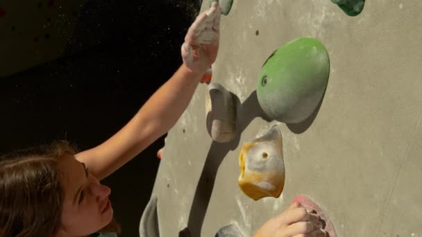 MACRO: Junges Mädchen versucht beim Klettern drinnen einen grünen Grip zu ergreifen — Stockvideo