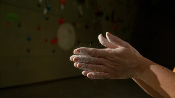 CLOSE UP: Oigenkännlig kvinna klappar händerna efter krita upp på klättring gym — Stockvideo