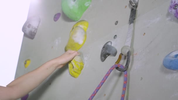 Sluiten omhoog: jong blank meisje quickdraws haar belay touw in een karabijnhaak. — Stockvideo