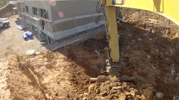 POV: Těžba nečistot a skal v blízkosti domu ve výstavbě ve slunné krajině — Stock video