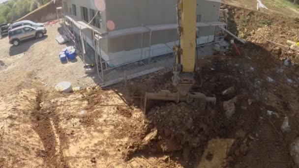 POV: Brazo de excavadora con cubo de zanja excavando tierra en un sitio de construcción . — Vídeo de stock