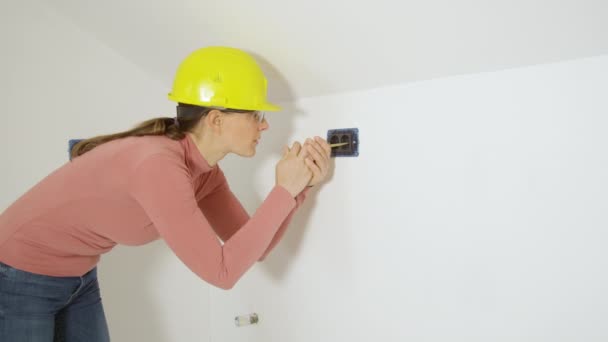 CLOSE UP: Electrician checks the electric current in newly installed sockets — Stock Video