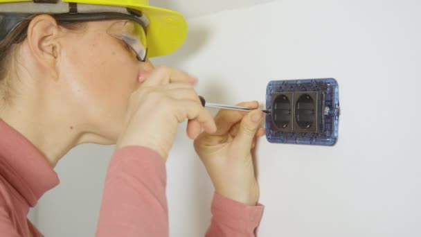 SLUITEN omhoog: Vrouwelijke elektricien schroeft twee stopcontacten, onthullen de elektrische bedrading — Stockvideo