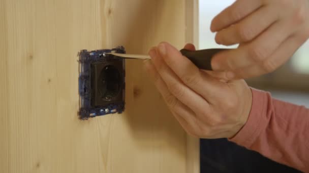 CLOSE UP: Detailed shot of a female electrician's hands as she screws an outlet — Stock Video