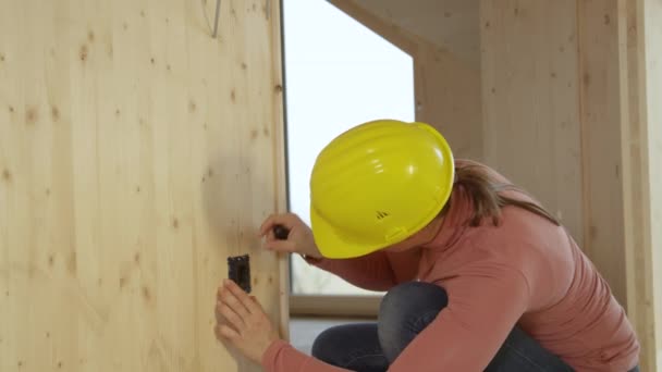 RETRATO: Eletricista sorrisos femininos depois de apertar os parafusos em um soquete — Vídeo de Stock