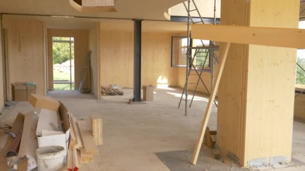 CLOSE UP: Worker carries a log across the first floor of a prefabricated house. — Stock Video