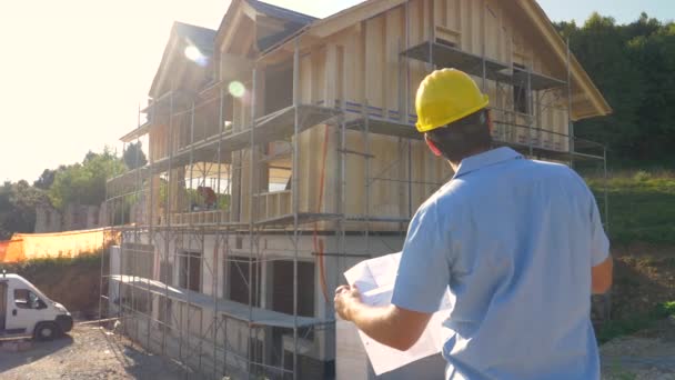 CLOSE UP: Unrecognizable construction site manager looks at the floor plans. — Stock Video