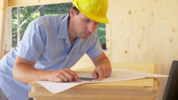 CLOSE UP: Construction site overseer shicks his head while looking at plans. — стоковое видео