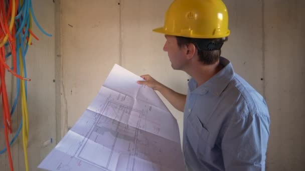 FECHAR UP: Superintendente de construção inspeciona instalações com plantas na mão. — Vídeo de Stock