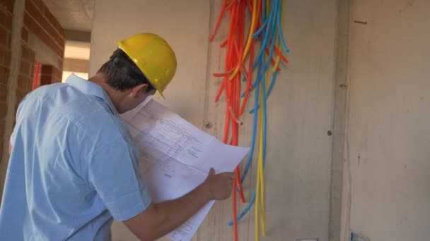 FERMETURE : Le superviseur de la construction examine les plans lors de la vérification des installations — Video