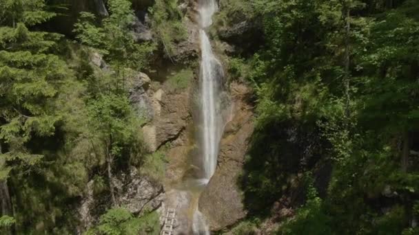 AERIAL: Voando até uma cachoeira em cascata de tirar o fôlego no cénico vale Logar. — Vídeo de Stock