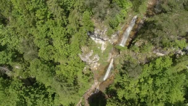 AERIAL: Filmový pohled na nádherný kaskádový vodopád v zeleném údolí Logar. — Stock video