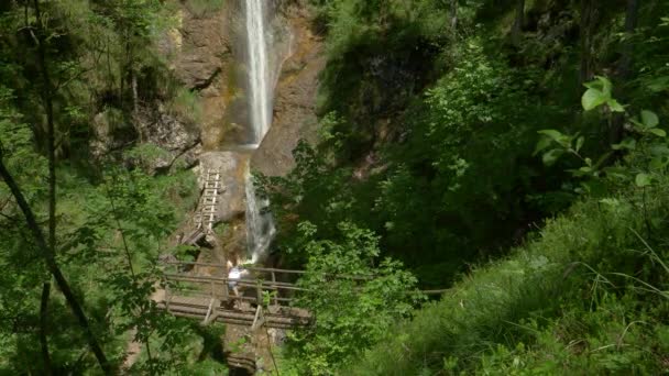 Onherkenbare vrouwelijke toerist maakt een foto van de adembenemende waterval. — Stockvideo