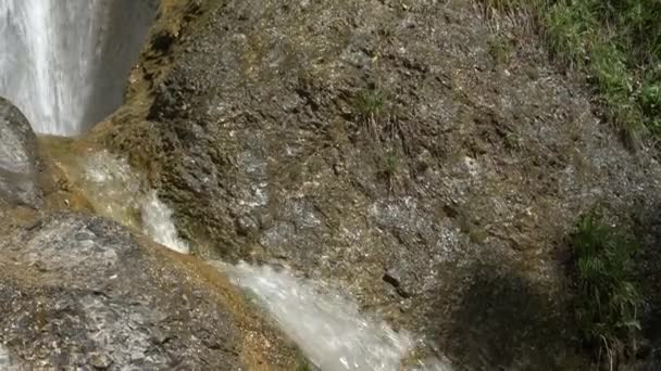 CLOSE UP: Detailansicht des kristallklaren Bachwassers, das glänzende Felsen hinunterrauscht. — Stockvideo