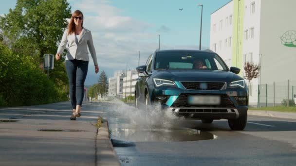 Affärskvinna som går längs trottoaren blir plaskad av vårdslös förare. — Stockvideo