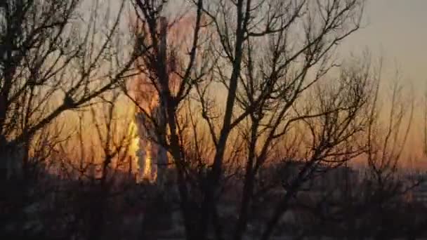 AERIAL: Lange verwarmingsinstallatie schoorsteen torens in de verbrande oranje avondlucht. — Stockvideo