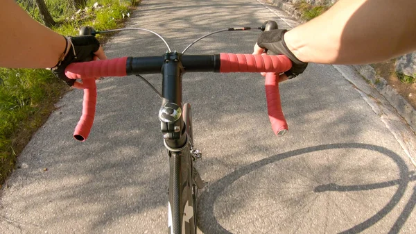 POV: Primer disparo en persona de pedalear una bicicleta en las montañas soleadas . —  Fotos de Stock