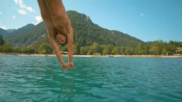 CLOSE UP : L'homme caucasien en forme plonge la tête la première dans le lac d'émeraude rafraîchissant. — Photo