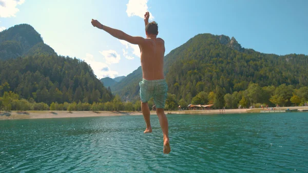 ZAMKNIJ SIĘ: Radosny biały mężczyzna nurkuje w odświeżającym szmaragdowym jeziorze. — Zdjęcie stockowe