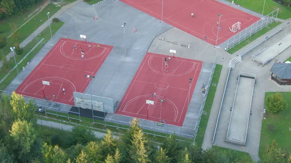 AERIAL: Människor som idrottar på de nya domstolarna nära medelklassen grannskap. — Stockfoto