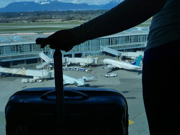 CERRAR: Mujer irreconocible sosteniendo su equipaje mientras observa el aeropuerto . — Foto de Stock