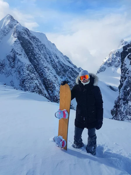 Emocionada snowboarder posa com seu snowboard antes de descer a montanha . — Fotografia de Stock