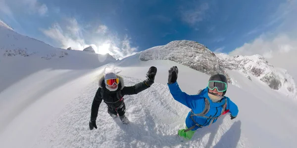 VR360: Glimlachend snowboarder paar high fives tijdens het wandelen op de ongerepte berg. — Stockfoto