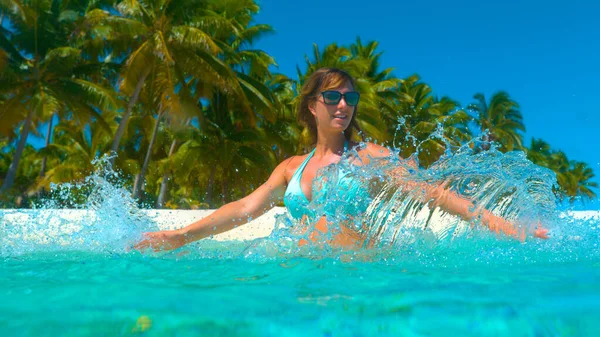 CERRAR: Joven alegre rociando el agua cristalina del océano con las manos . — Foto de Stock