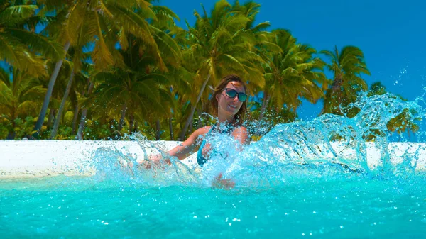 CERRAR: Fotografía cinematográfica de una chica caucásica jugando con el agua turquesa . — Foto de Stock
