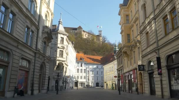 Turistická ulice v Lublani staré město běží prázdné pod krásným hradem na kopci — Stock video