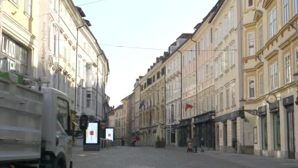 Śmieciarka jedzie pustą ulicą w starym mieście Lublana podczas kwarantanny — Wideo stockowe