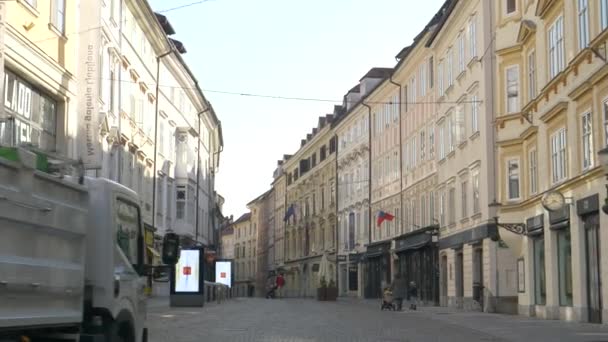 Eski kasaba Ljubljana 'da karantina sırasında çöp kamyonu boş sokaktan geçiyor. — Stok video