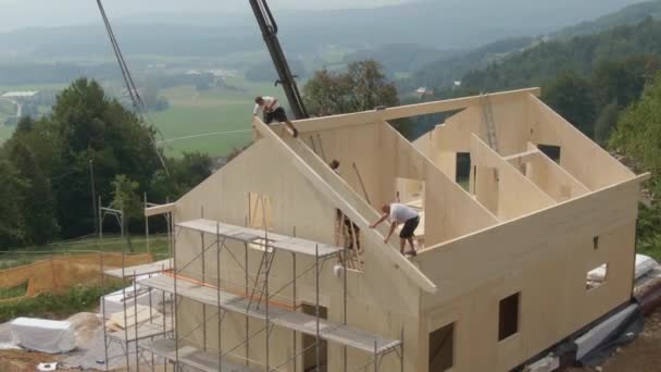 DRONE: Volando alrededor de una moderna casa de CLT que está siendo construida por valientes constructores. — Vídeos de Stock