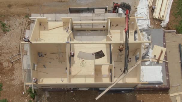 ARRIBA: Volando por encima de una moderna casa de madera laminada en cruz en construcción. — Vídeos de Stock