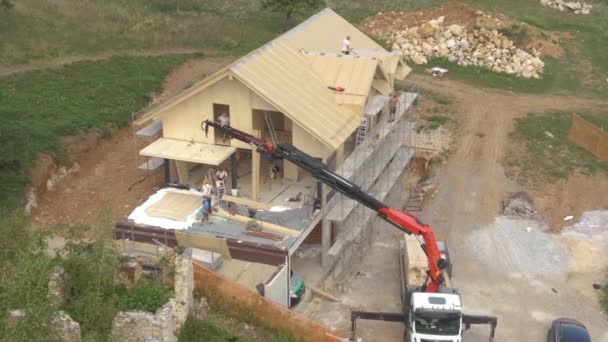 DRONE: Los carpinteros terminan montando láminas de madera en el techo de una casa CLT — Vídeos de Stock