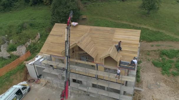 DRONE: Létání nad domem, zatímco dodavatelé pokládají izolační plachty na střechu. — Stock video