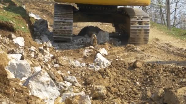 CERRAR: Cubo del destripador excavando tierra y rocas en un sitio de construcción. — Vídeos de Stock