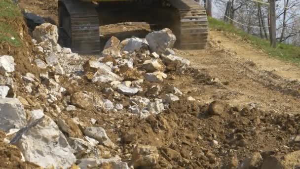 CLOSE UP: Excavator operator drives along dirt trail after a long day at work. — Stock Video