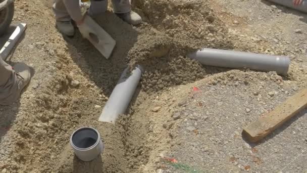 关闭：一组无法辨认的承包商组装了一条新的污水管道. — 图库视频影像